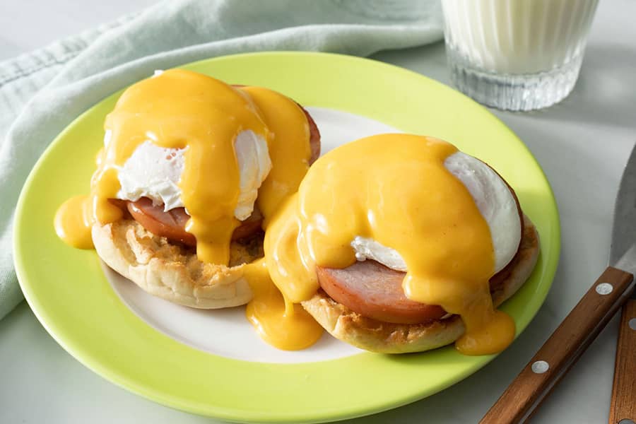 What type of sauce is commonly served atop Eggs Benedict?